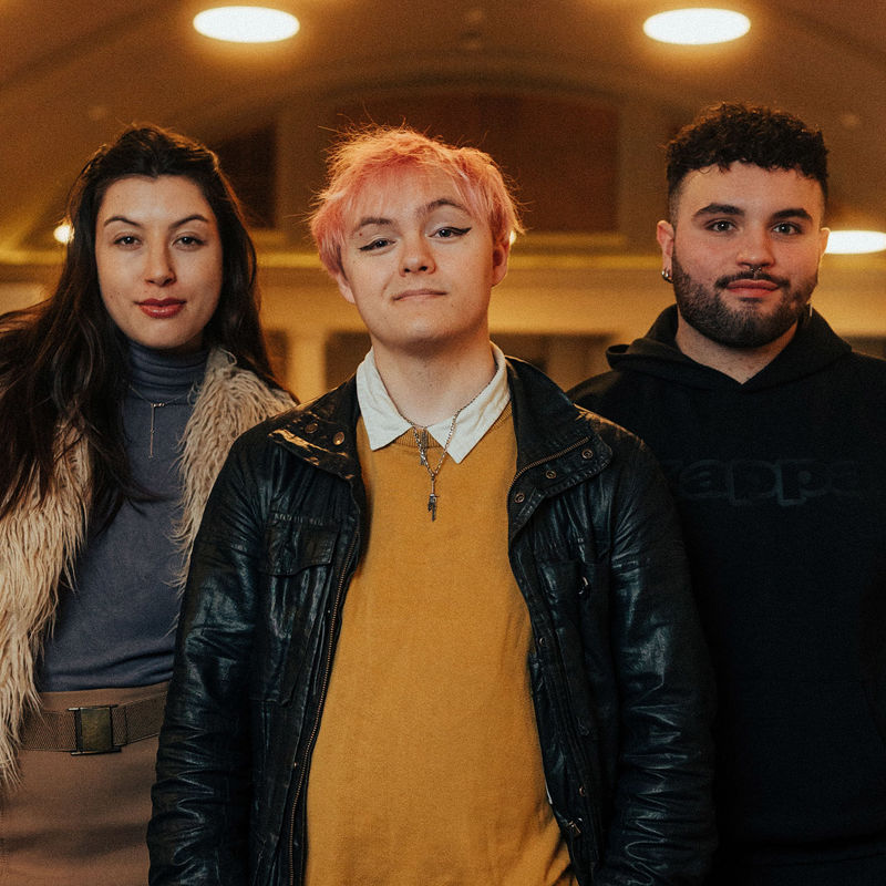 3 students standing in a line on campus