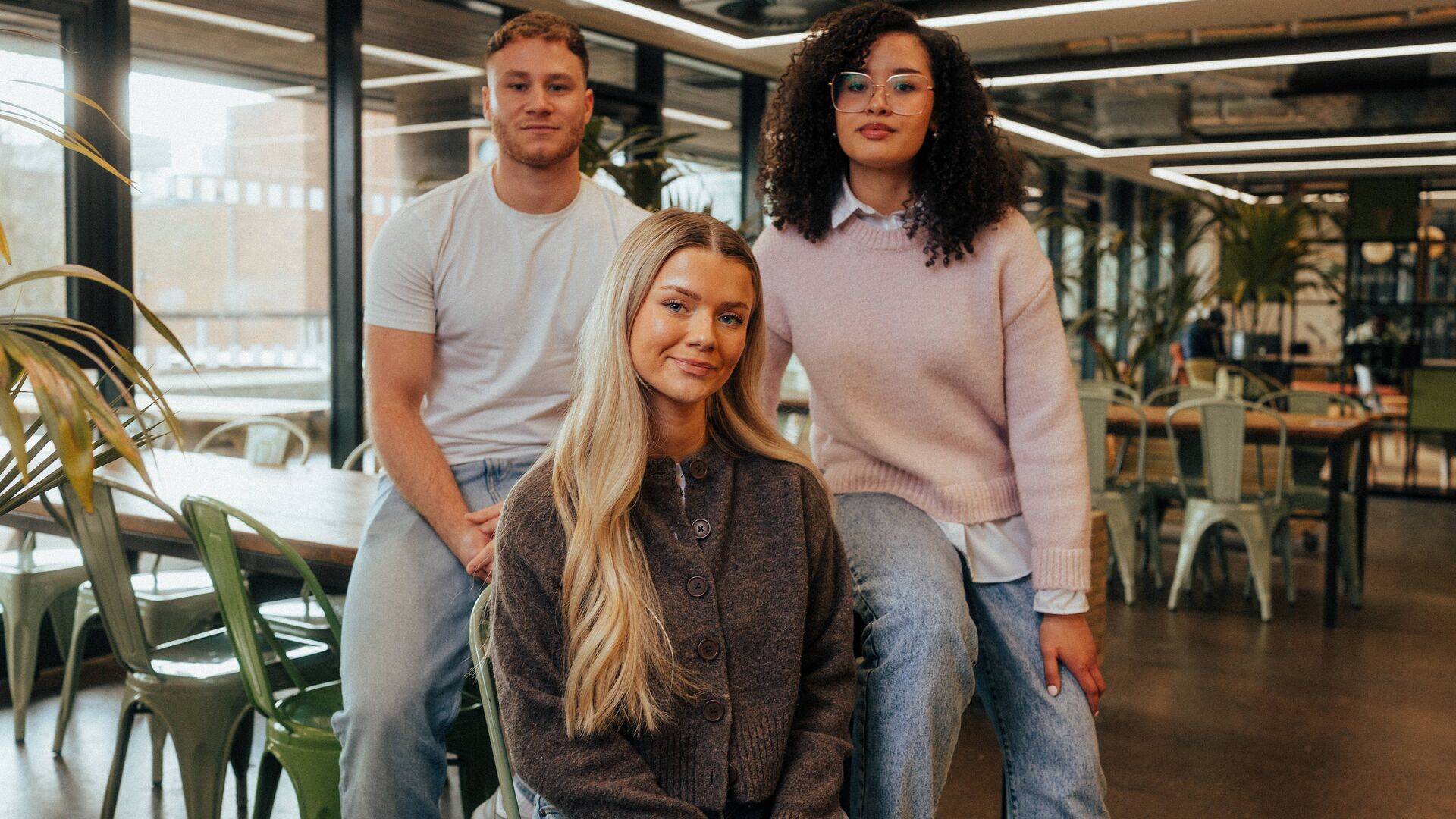 3 students sat on a table upstairs in the students' union