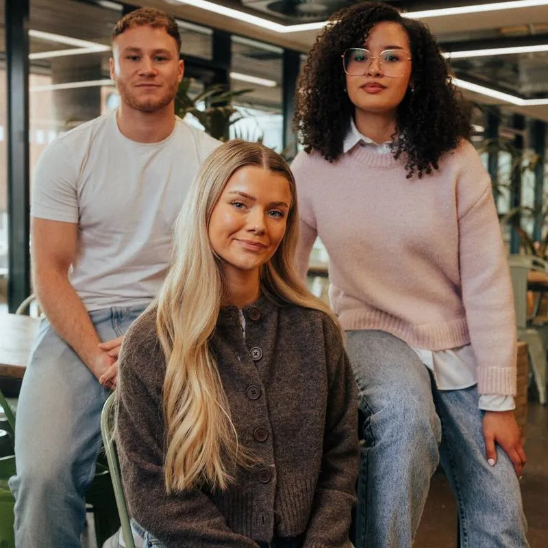 3 students sat on a table upstairs in the students' union