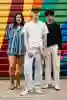 3 students standing in front of graffiti covered shop shutter