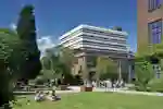 Library with student sitting on lawn in the foreground
