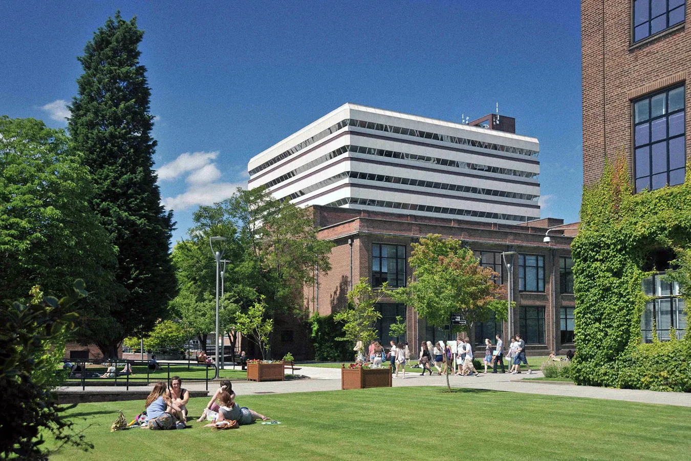 Library with students sitting on lawn in the foreground