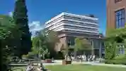 Exterior of the Brynmor Jones library with students sat on the grass in the foreground