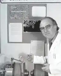 george william gray standing in a lab coat in front of the technology used in the development of lcds