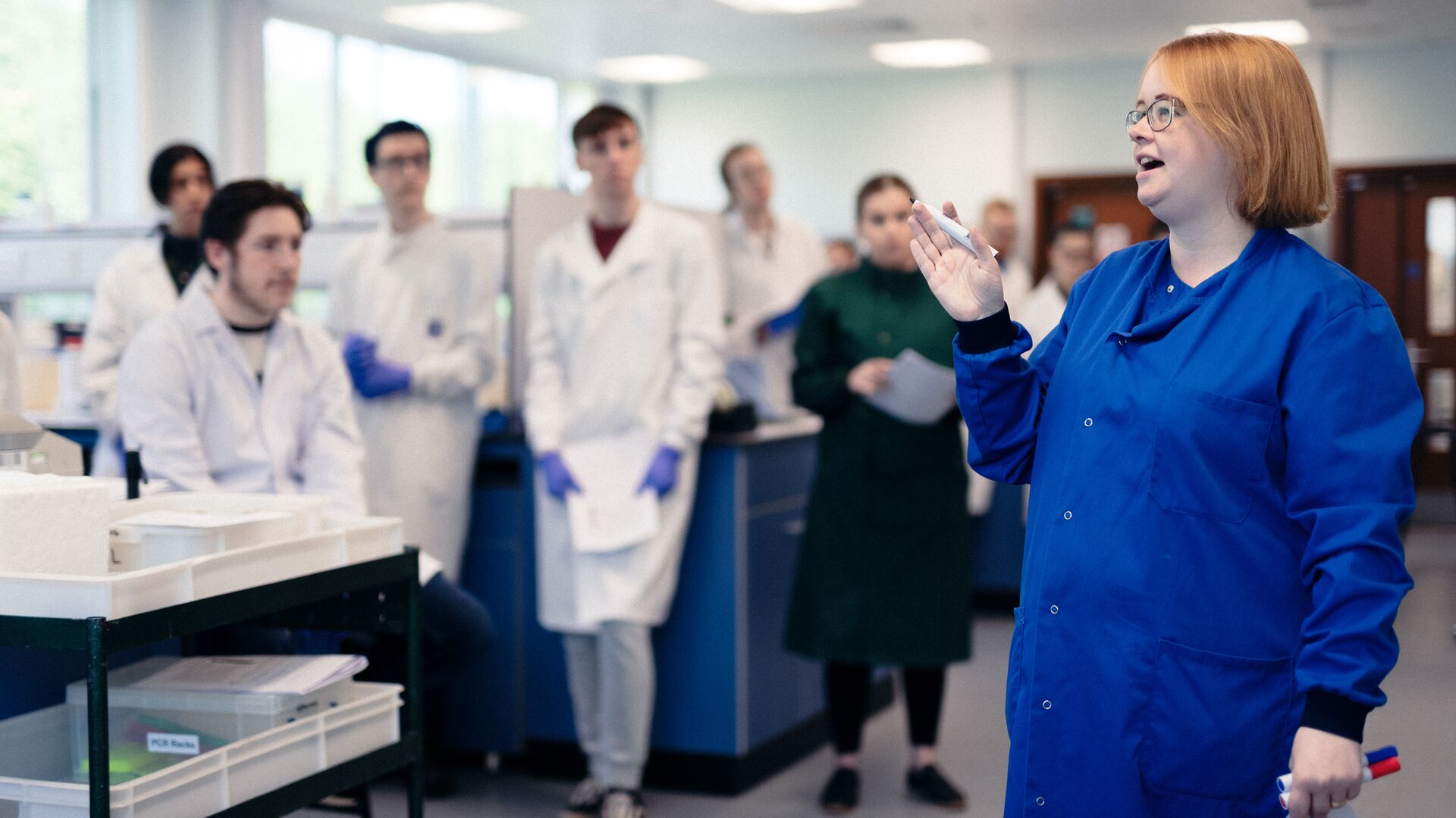 Teacher speaking to students in a biology lab