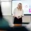 Lecturer stood smiling at the front of a classroom