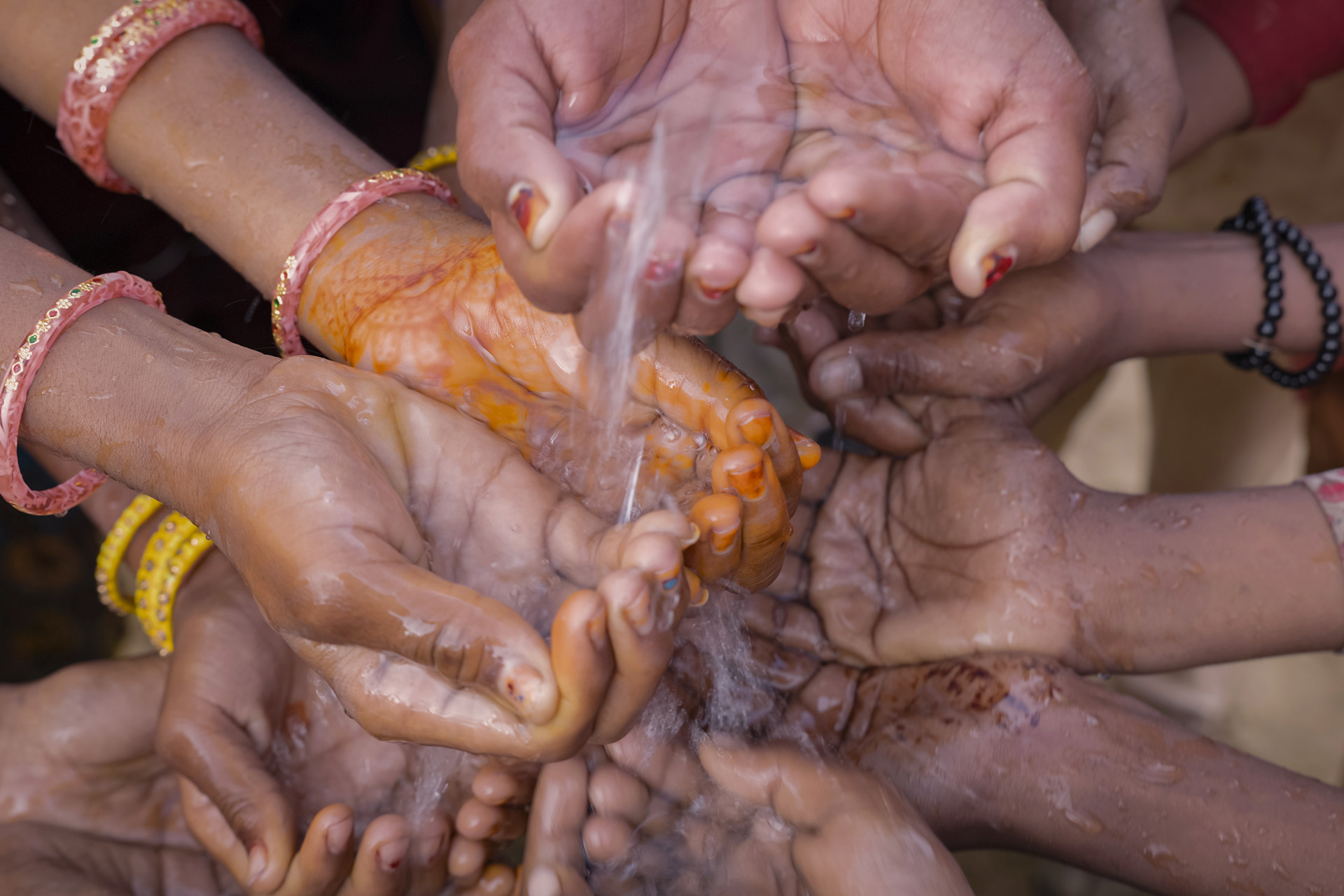 A number of female hands held together in desperation for running water
