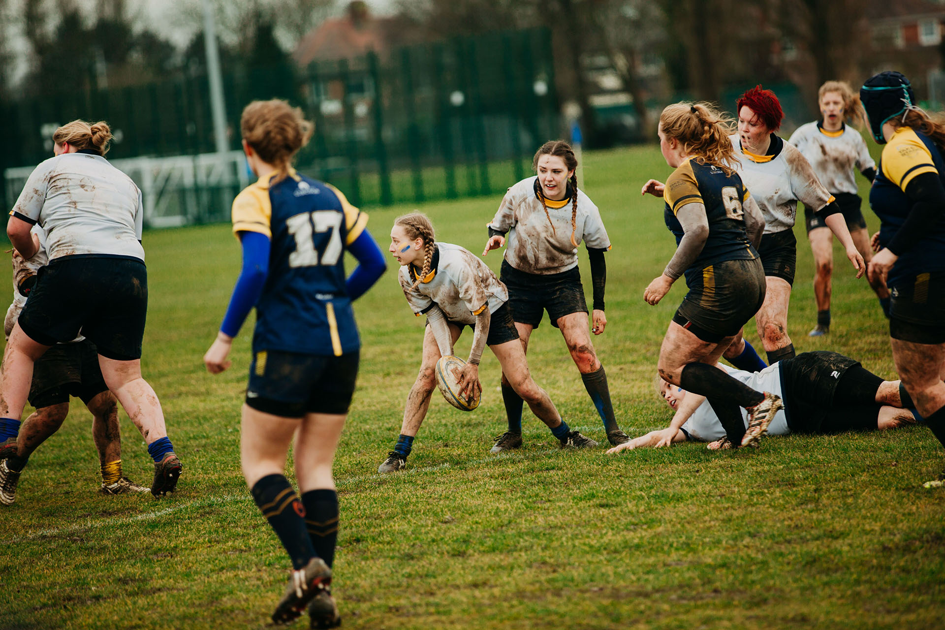 Women throwing rugby ball to team during Varsity match
