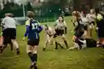 Women throwing rugby ball to team during Varsity match