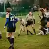 Women throwing rugby ball to team during Varsity match