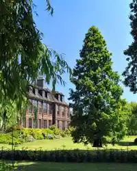 Venn building front lawn, trees and greenery on a sunny day