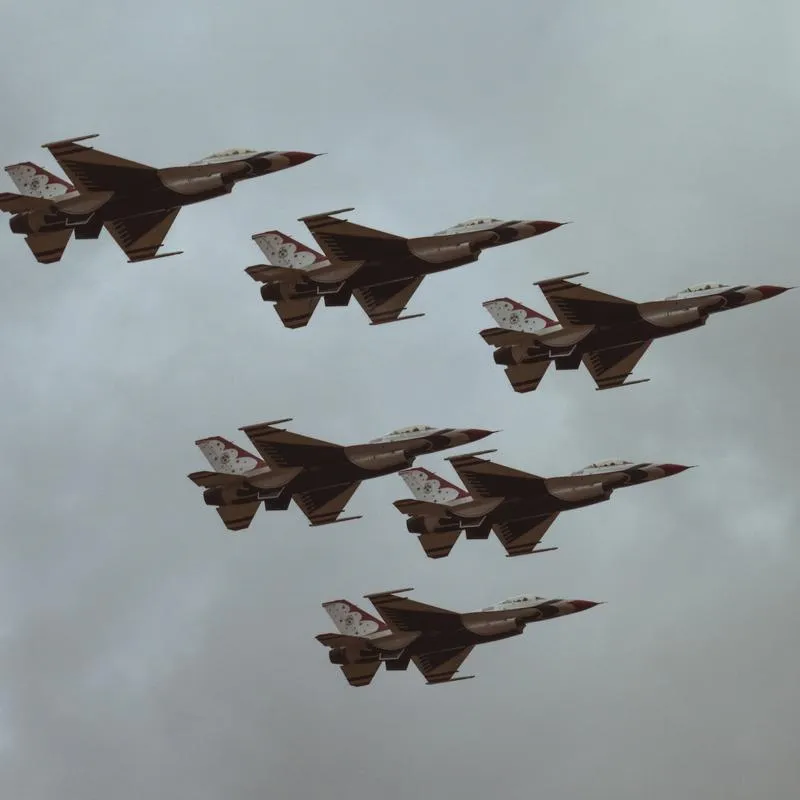 Six F16s Fighting Falcon aircraft flying through a cloudy sky