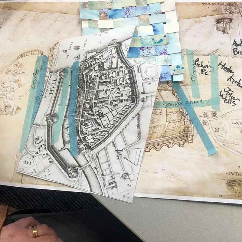 A collage of old maps, woven painted strips and hand drawn labels