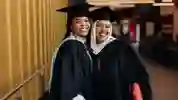 Two female students posing in their graduation cap and gowns