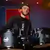 A student playing the drums in a studio