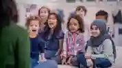 children sat on a playmat together listening to a story