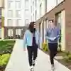 Two students chat while walking outside our modern Westfield Court accommodation blocks.