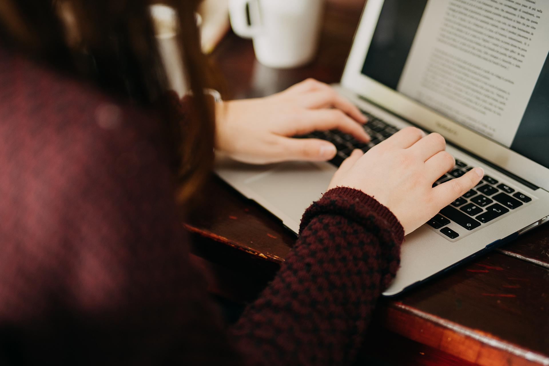 A student working on an essay on their laptop.