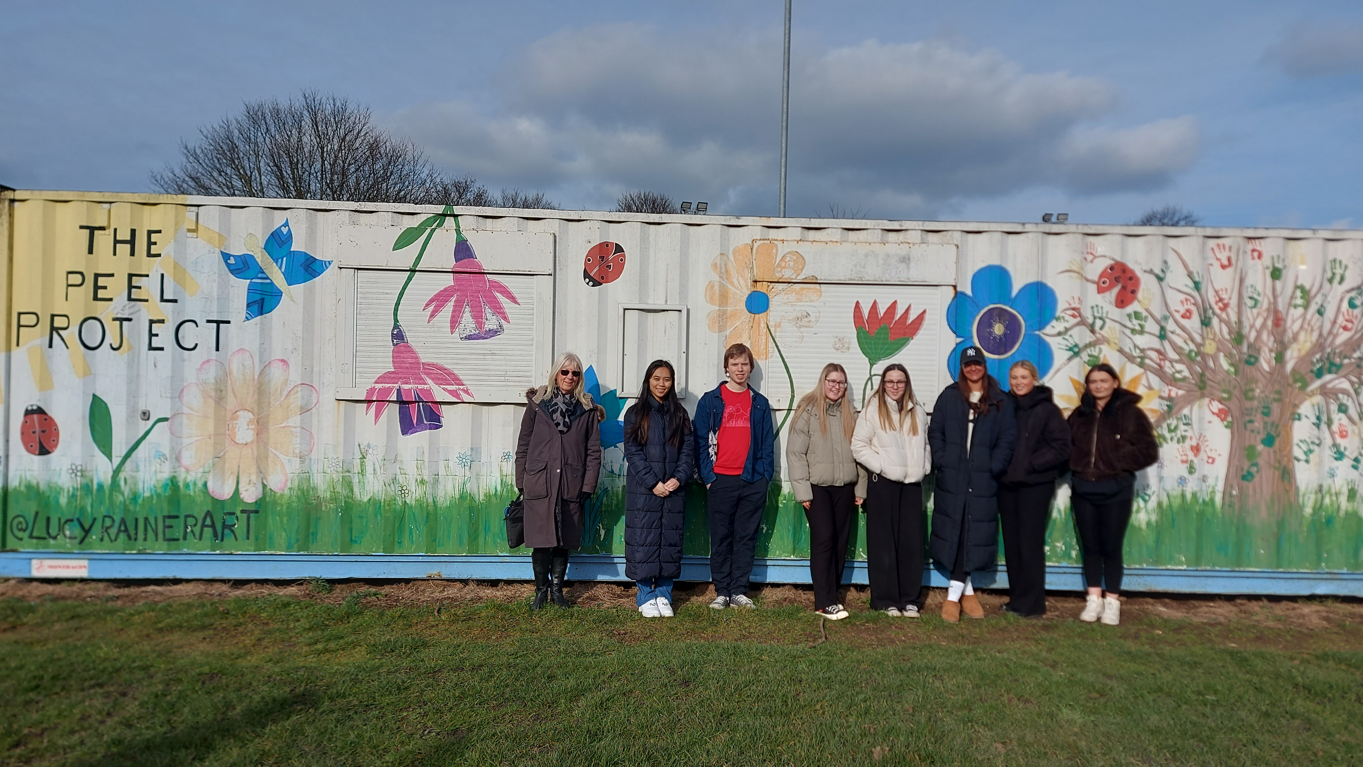 A group of students standing in front of a graffiti art project