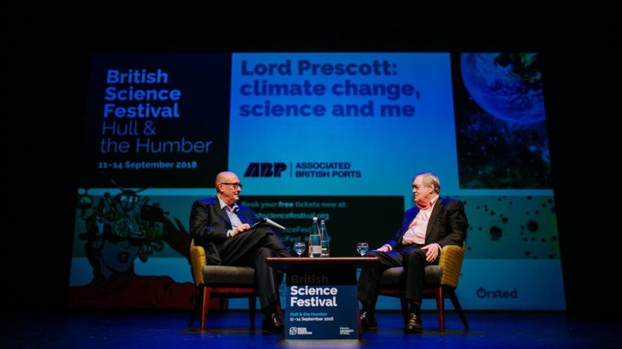 John Prescott sat on chair on stage with opposite person