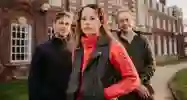 Three academics stood outside of a building