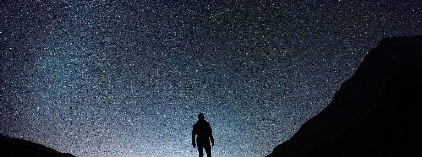 Man in silhouette looking out into the cosmos