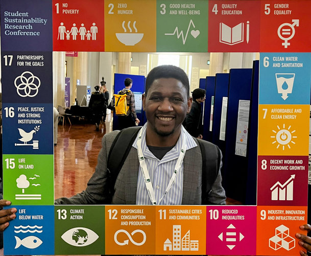 Blessing Mucherara holds a banner showing the United Nations Sustainable Development Goals Blessing Mucherara holds a banner showing the United Nations Sustainable Development Goals