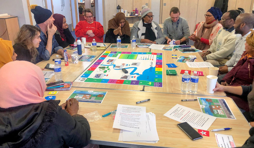 A flood risk management 'Serious Game' session run by Blessing Mucherera People playing board game