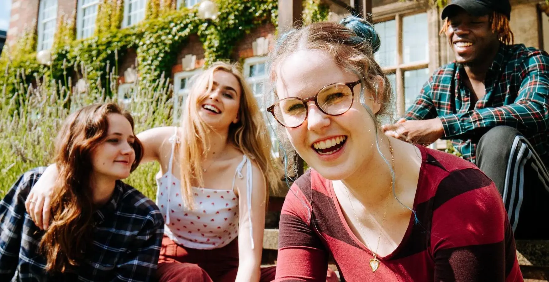 Students laughing sat on steps
