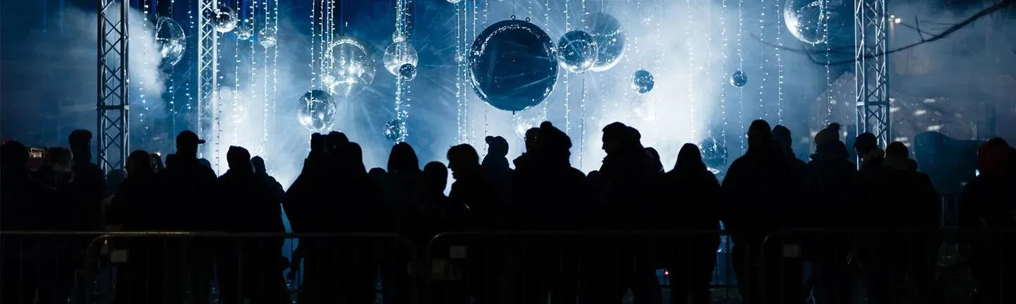 silhouetted people in darkened venue with strobes and metallic spheres