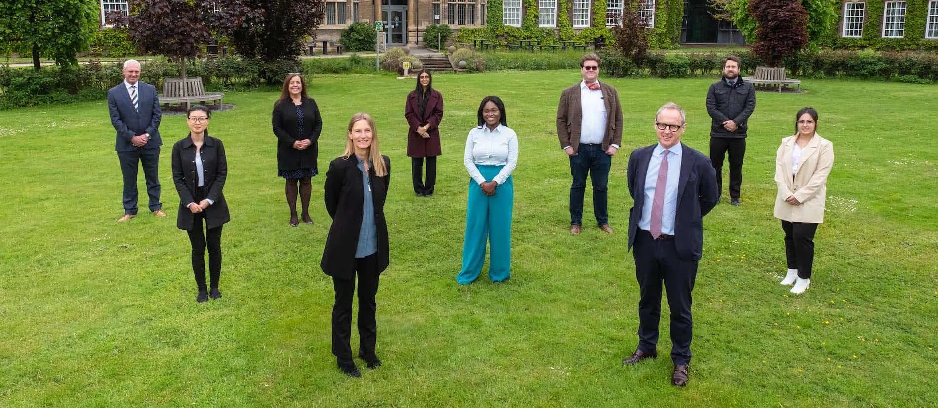 Scholars stood on some grass outside our Derwent business building