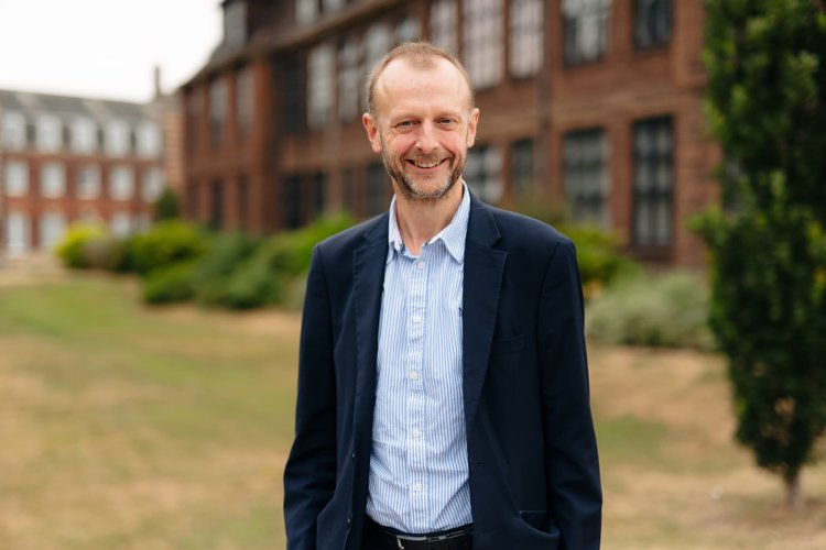 Professor Dave Petley stood on grass outside building