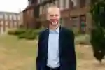 Professor Dave Petley stood on grass outside building