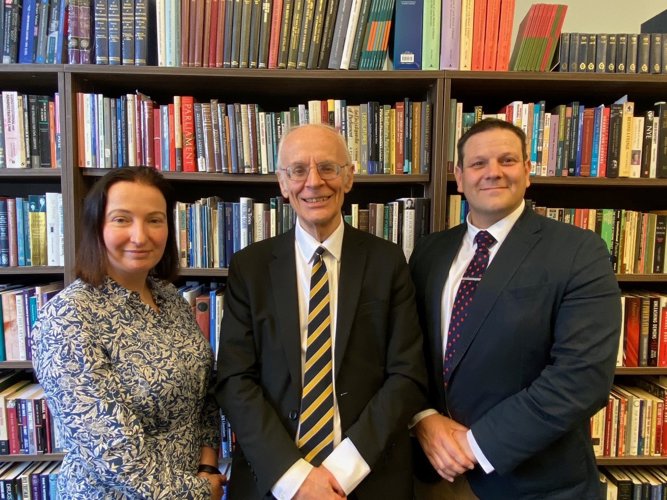 Politics academics stood in front of book case