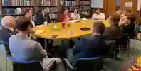 Council members sat around a table in discussion