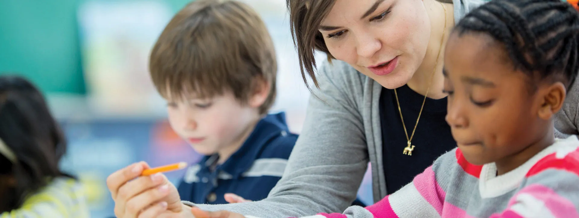 Female teacher with primary school children inthe  classroom