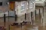 Flood waters around a building with a flood gate over the door