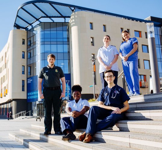 Health students at the award-winning Allam Medical Building Students sat on steps in front of Allam Medical Building