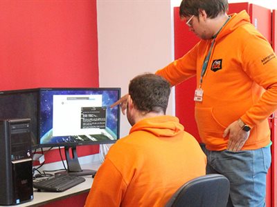 two students leaning over a computer.