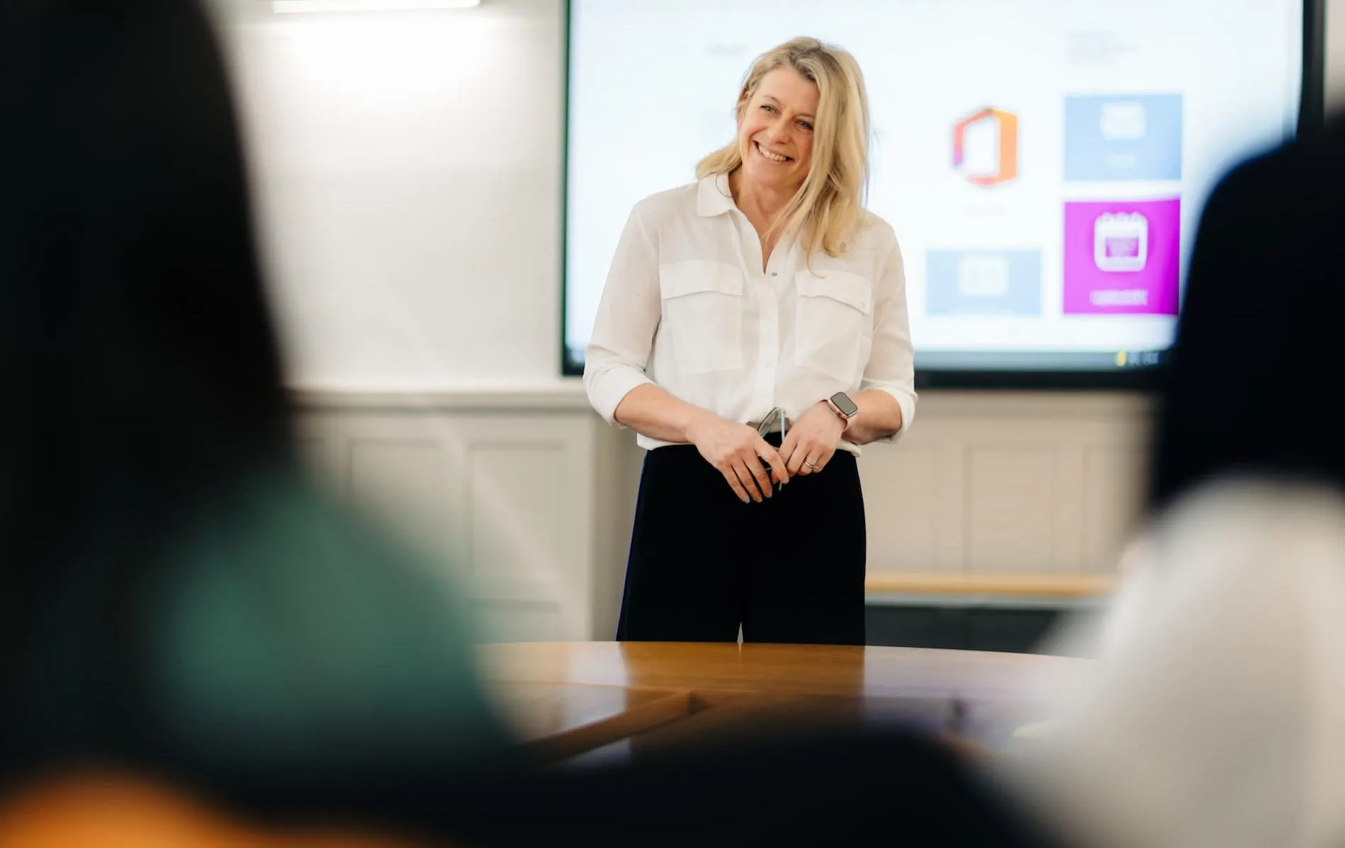 Person stood in front of smart board smiling