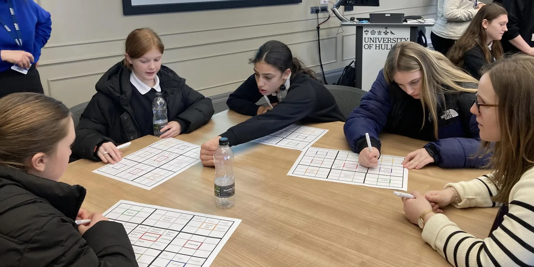 schoolchildren gathered around a table working on a project