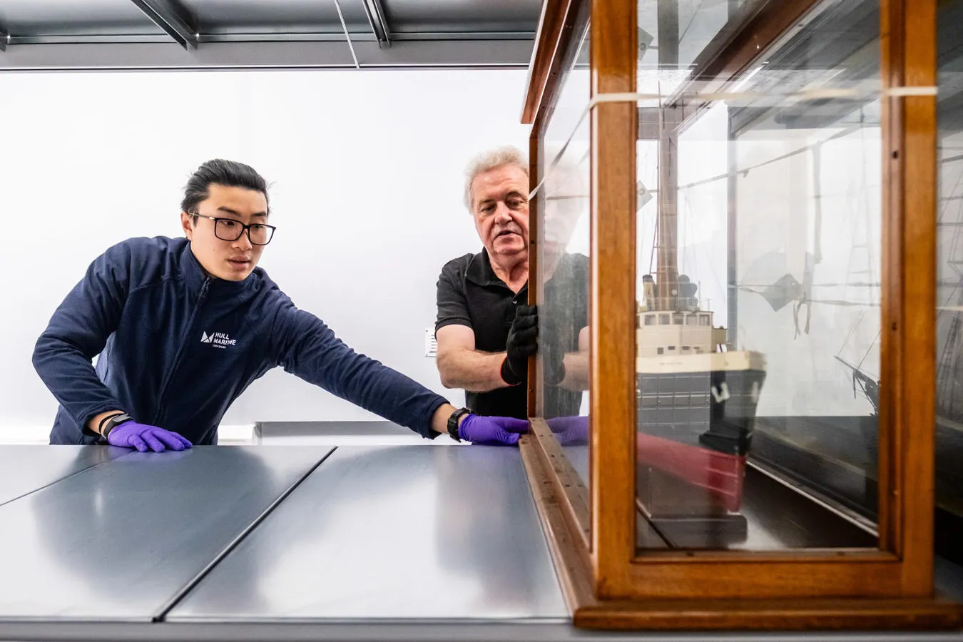 Hull University Student helps prepare an exhibit of a model ship for the museum