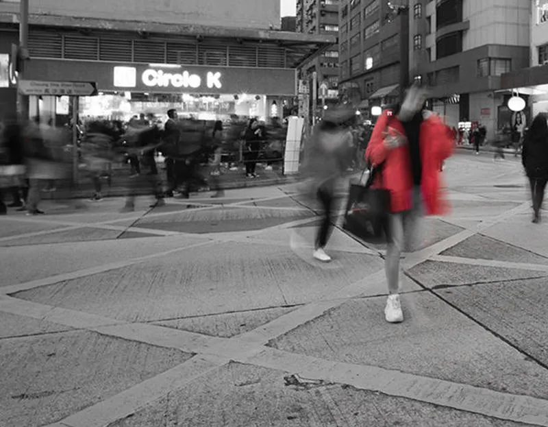 A busy city street with a blurred image of a woman in the foreground