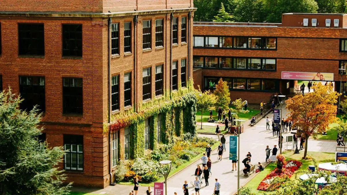Looking down from high vantage point on ivy covered building and people walking by