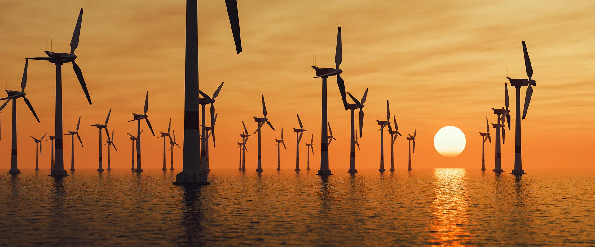 Offshore wind turbines silhouetted against a sunrise