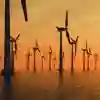 Offshore wind turbines silhouetted against a sunrise