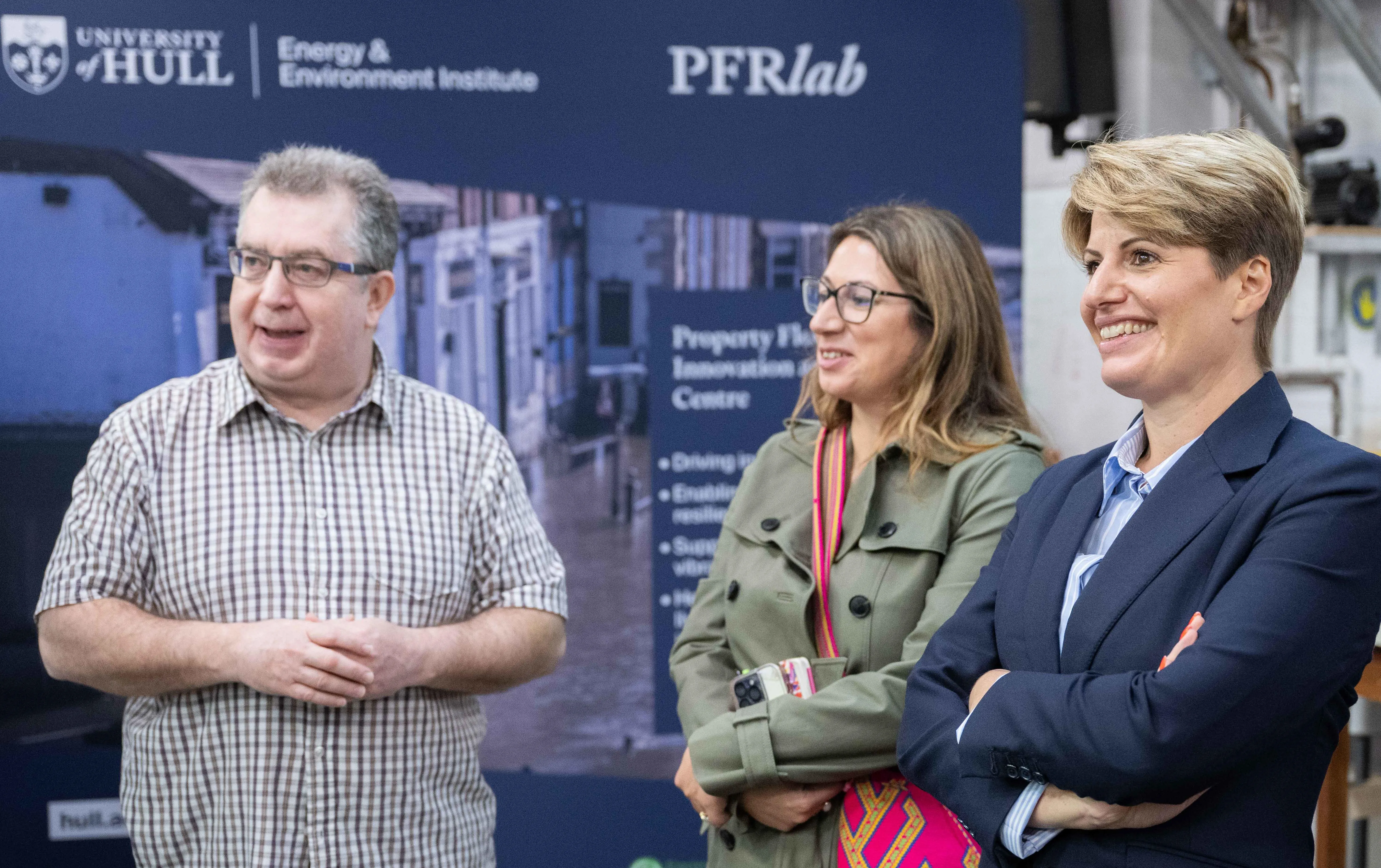 Three people standing in front of PFRlab banner