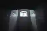 A barred window illuminates a bare prison cell