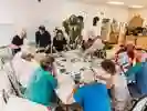 Community group working around a large table handling and viewing a variety of images