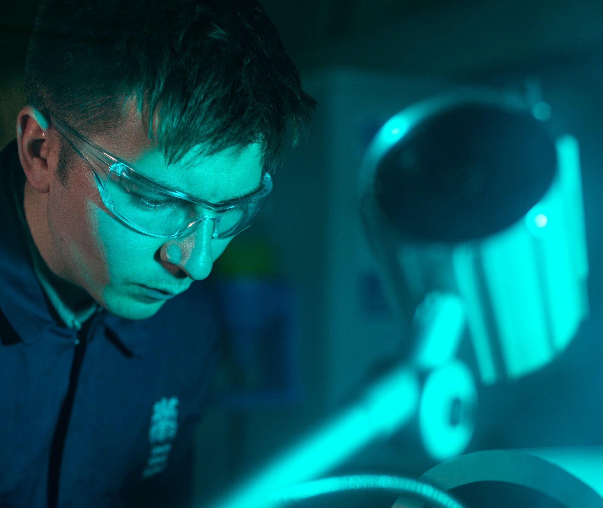 man in protective eyewear operating machinery